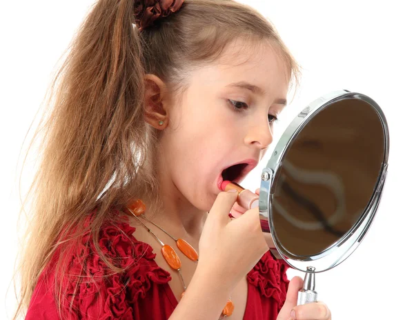 Little girl in her mother's dress, is trying painting her lips, isolated on white — Stock Photo, Image