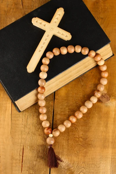 Les perles de chapelet en bois et la bible sainte sur fond en bois close-up — Photo