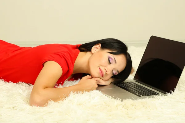 Mooie jonge vrouw in slaap op de laptop in de kamer — Stockfoto