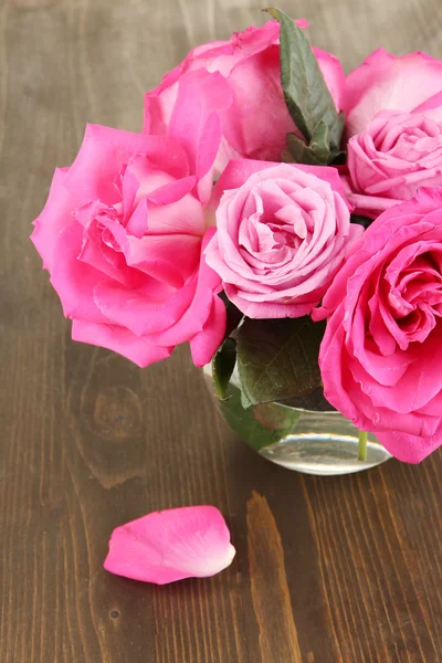 Krásné růžové růže ve váze na dřevěný stůl detail — Stock fotografie