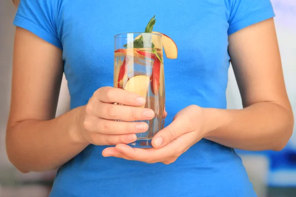 Bicchiere di bevanda alla frutta con cubetti di ghiaccio in mano — Foto Stock