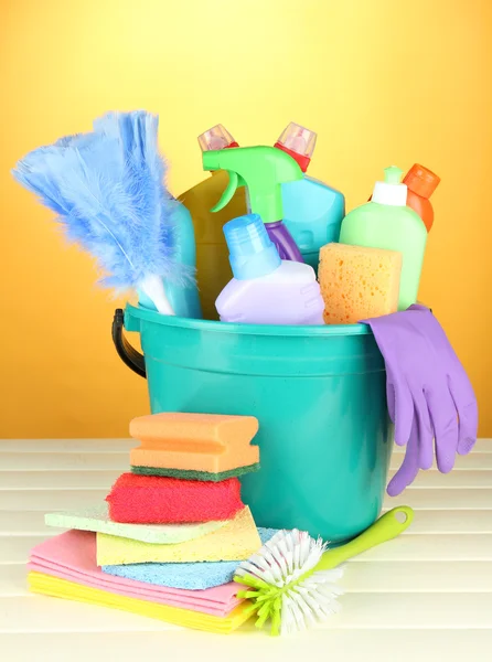 Schoonmaak items in emmer op kleur achtergrond — Stockfoto