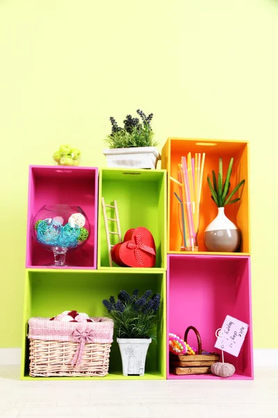Estantes de diferentes colores brillantes con adición decorativa en el fondo de la pared — Foto de Stock