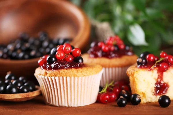 Muffins saborosos com bagas na mesa de madeira — Fotografia de Stock