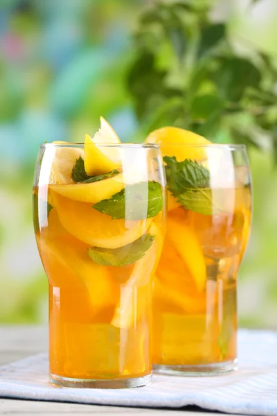 Tè freddo con limone e menta sul tavolo di legno, all'aperto — Foto Stock