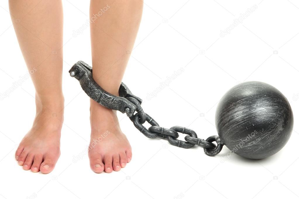 Legs in heavy iron shackles isolated on white