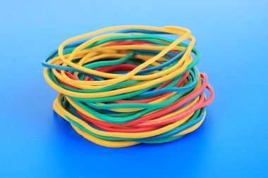 Colorful rubber bands on blue background clipart