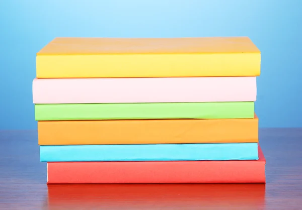 Stack of multicolor books on blue background — Stock Photo, Image