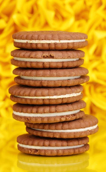 Chocolade koekjes met romige laag op gele decoratieve achtergrond — Stockfoto