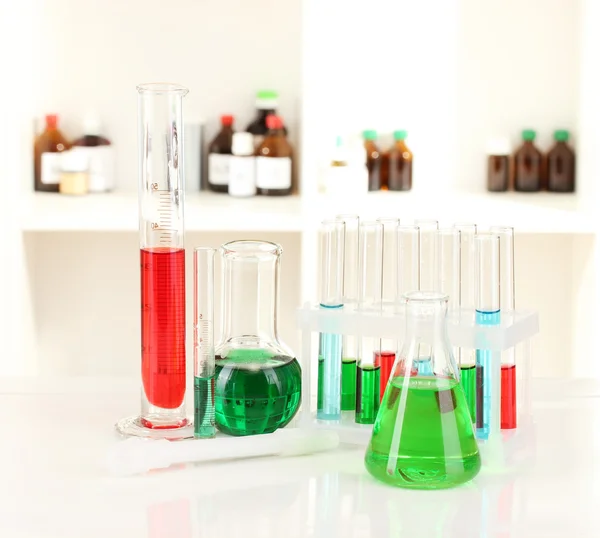 Different laboratory glassware with color liquid on laboratory background — Stock Photo, Image