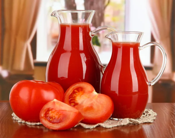 Jus de tomate dans les pichets sur la table dans la chambre — Photo