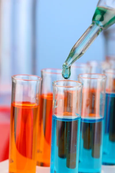 Laborpipette mit Farbtropfen über Reagenzgläser, Nahaufnahme — Stockfoto