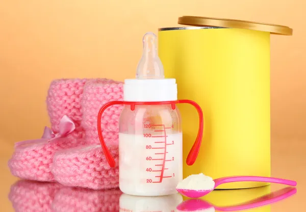 Bottle with milk and food for babies on beige background — Stock Photo, Image