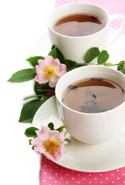 Xícaras de chá de ervas com flores de rosa do quadril, isolado em branco — Fotografia de Stock