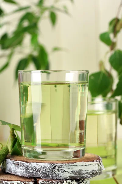 Vasos de savia de abedul sobre mesa de madera verde — Foto de Stock