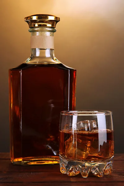 Brandy com gelo na mesa de madeira no fundo marrom — Fotografia de Stock