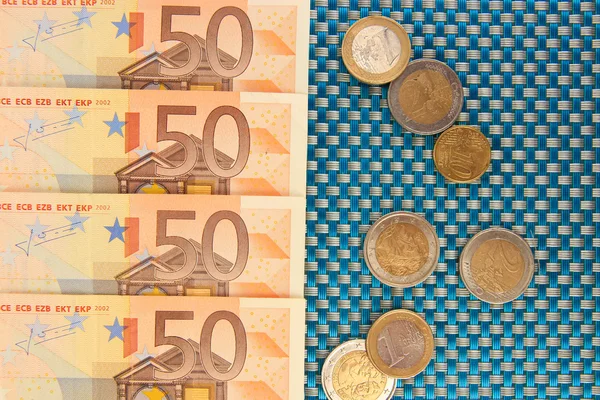 Bancnotele euro și cenții euro pe fundal albastru — Fotografie, imagine de stoc