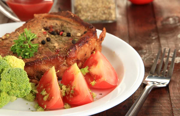 Piece of fried meat on plate on wooden table close-up — Stock Photo, Image