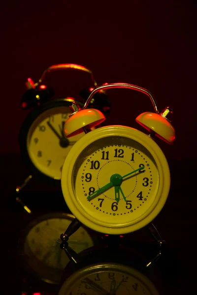 Dois relógios de alarme de estilo antigo no fundo de cor escura — Fotografia de Stock