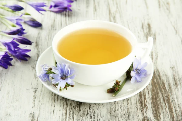 Cup of tea with chicory, on wooden background — Stock Photo, Image