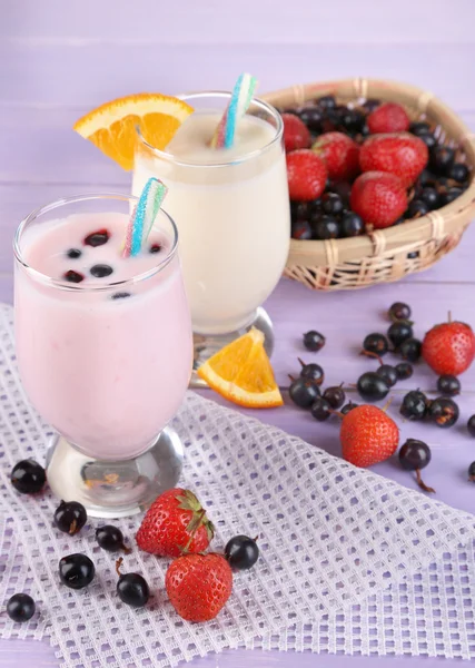 Leckere Milchshakes mit Orange und Brombeere auf Holztisch in Großaufnahme — Stockfoto