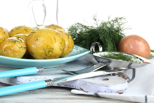 Gekookte aardappelen op platen op houten bord in de buurt van servet op houten tafel — Stockfoto