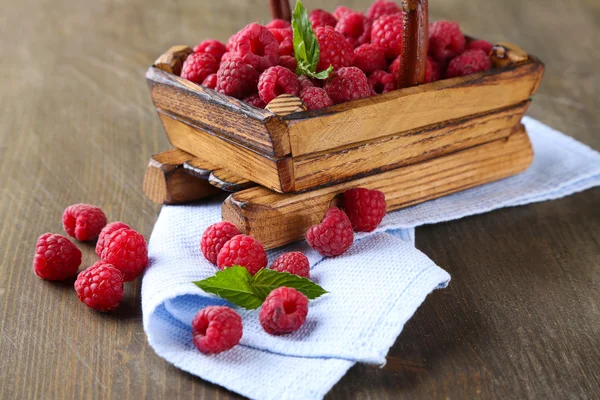 Спелые сладкие малины в корзине на деревянном фоне — стоковое фото