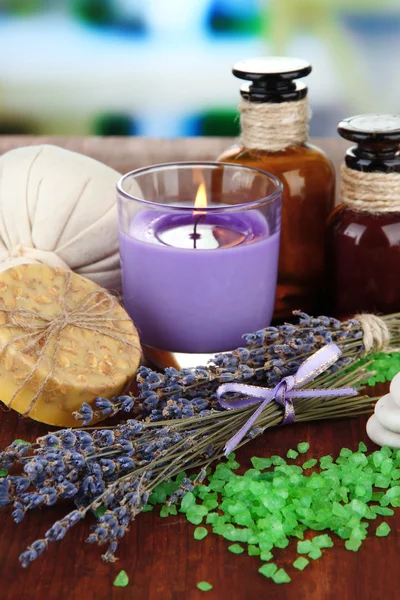 Stilleven met lavendel kaars, zeep, massage ballen, flessen, zeep en verse lavendel, op houten tafel op lichte achtergrond — Stockfoto