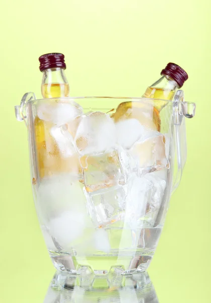 Minibar bottles in bucket with ice cubes, on color background — Stock Photo, Image