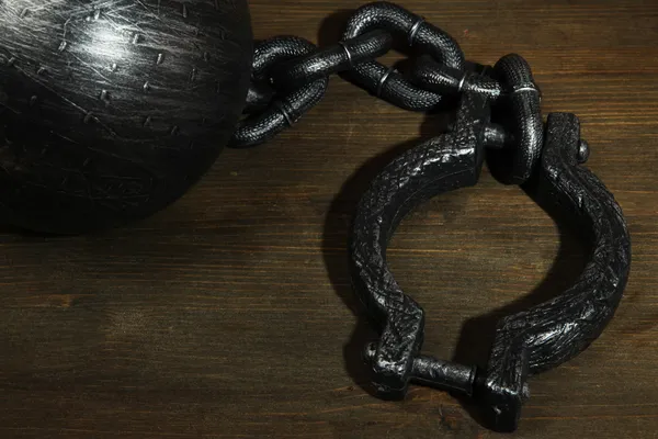 Ball and chain on wooden background — Stock Photo, Image