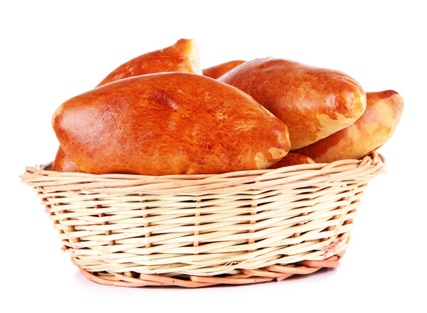 Fresh baked pasties in wicker basket, isolated on white