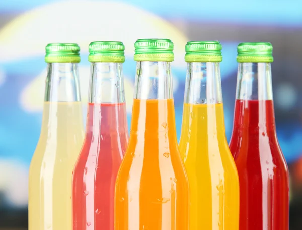 Bottles with tasty drinks on bright background — Stock Photo, Image