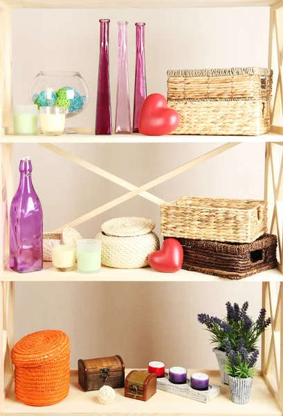 Beautiful white shelves with different home related objects, on color wall background — Stock Photo, Image