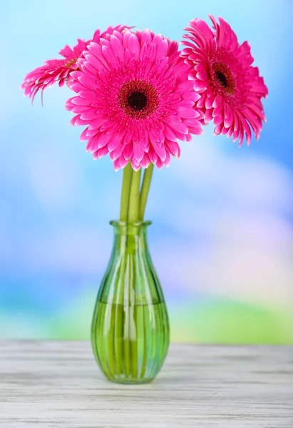 Belas flores de gerbera rosa em vaso na mesa de madeira — Fotografia de Stock