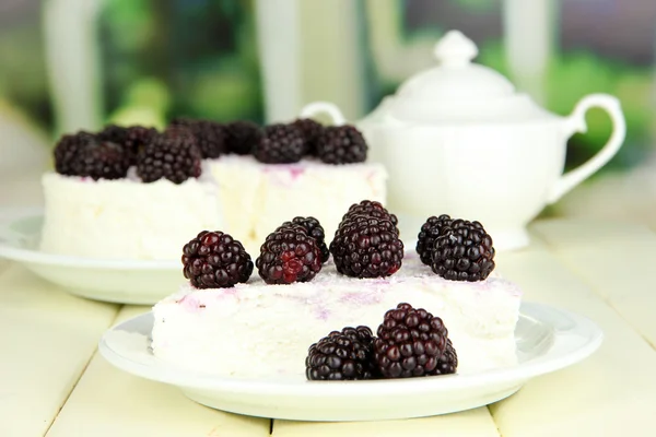 Cheesecake with fresh berries on white plate on wooden table — Stock Photo, Image