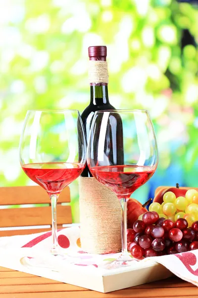 Copos de vinho no guardanapo na bandeja na mesa de madeira no fundo da natureza — Fotografia de Stock