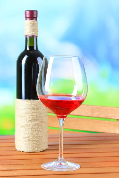 Glass of wine on wooden table on nature background — Stock Photo, Image