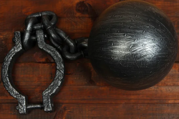 Piłka i łańcucha na drewniane tła — Zdjęcie stockowe