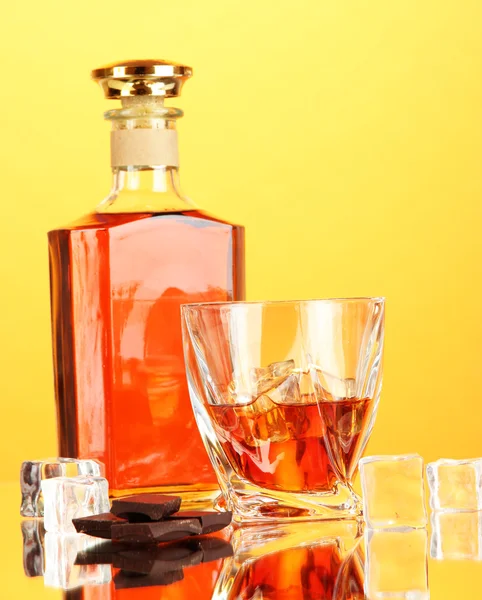 Fles en twee glazen van scotch whisky, op een achtergrond met kleur — Stockfoto