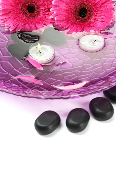 Wellness-Steine, Gerbera-Blumen und Kerzen auf Wasser, isoliert auf Weiß — Stockfoto