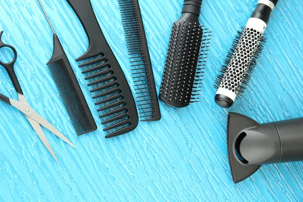 Comb brushes, hairdryer and cutting shears,on color background — Stock Photo, Image