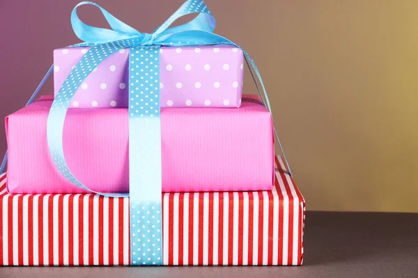 Gift box tied with a ribbon on a color background — Stock Photo, Image