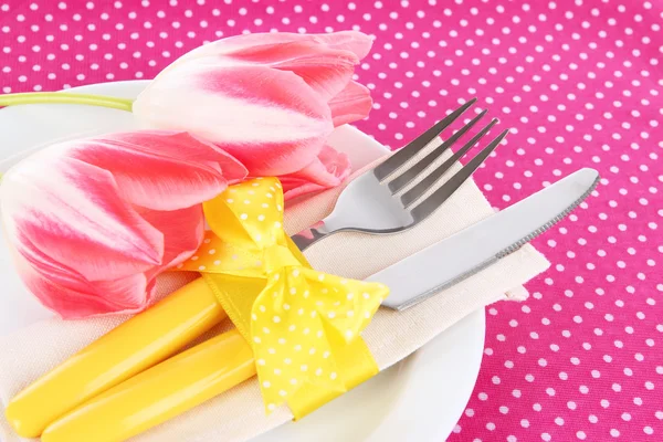 Cenário festivo da mesa de jantar com tulipas no fundo rosa polka-dot — Fotografia de Stock