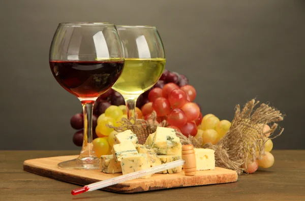 Komposition mit Wein, Blauschimmelkäse und Trauben auf Holztisch, auf grauem Hintergrund — Stockfoto