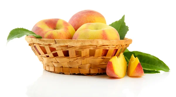Стиглі солодкі персики з листям в кошику, ізольовані на білому — стокове фото
