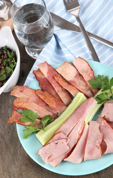 Bacon on plate on napkin on board on window table — Stock Photo, Image
