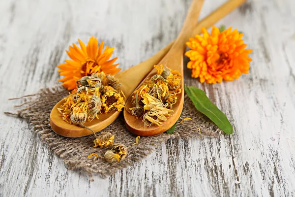 Frische und getrocknete Ringelblumen auf Holzgrund — Stockfoto