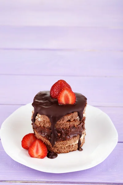 Schokoladenkuchen mit Erdbeere auf Holztisch in Großaufnahme — Stockfoto
