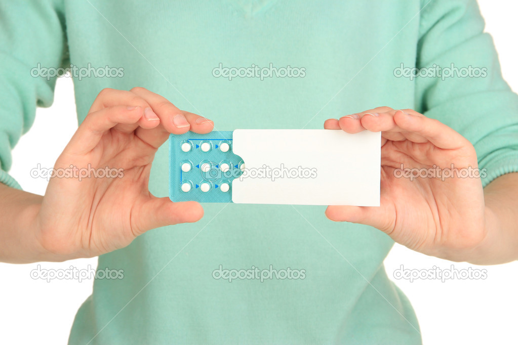 Hormonal pills in female hands isolated on white