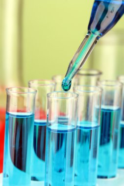Laboratuvar pipet renkli sıvı cam test tüpleri üzerinde damla ile yakın çekim